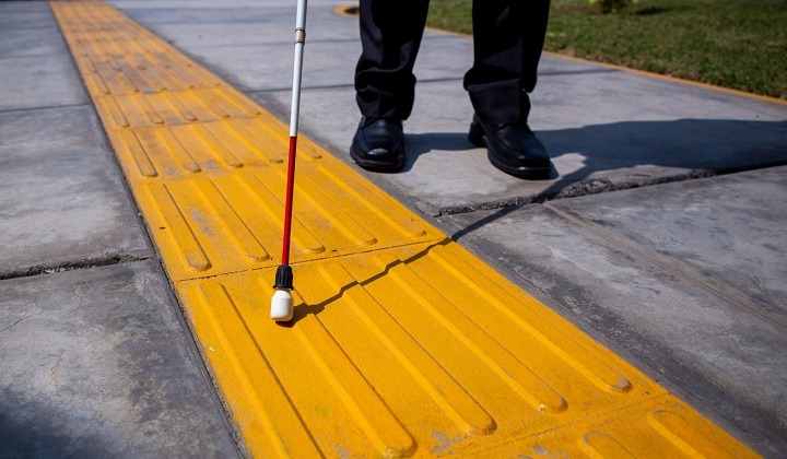 ¿Qué debo tener en cuenta antes de ayudar a una persona con discapacidad en calles o avenidas?