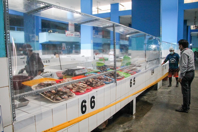 En mercado de peces implementan láminas protectoras para evitar contacto entre clientes y productos